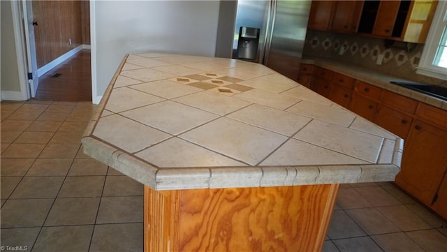 kitchen with tile patterned flooring, a center island, and stainless steel fridge with ice dispenser