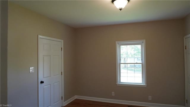 spare room with dark wood-type flooring