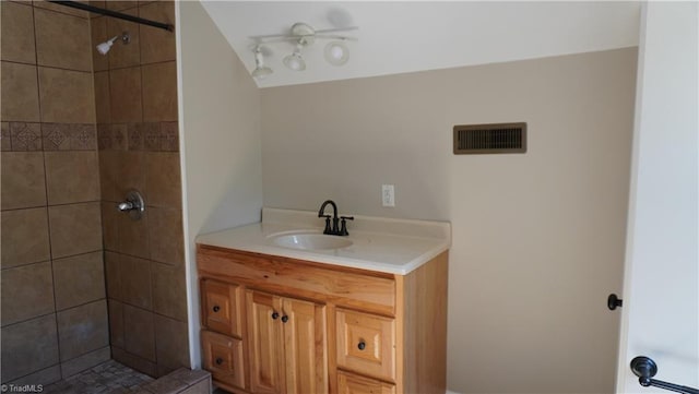 bathroom featuring a tile shower and vanity