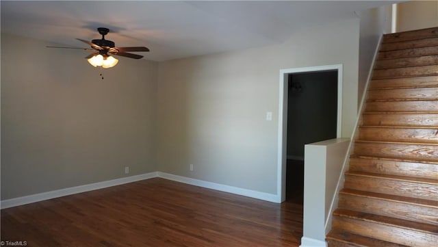 stairs featuring ceiling fan and hardwood / wood-style flooring