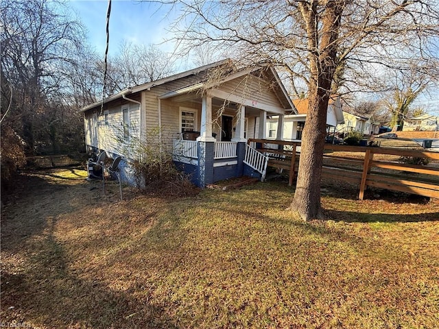 bungalow with a porch and a front lawn