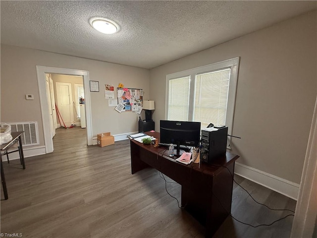 office with hardwood / wood-style floors and a textured ceiling