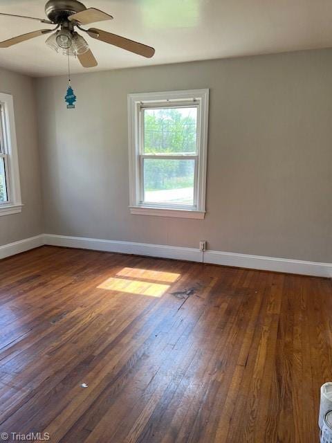 spare room featuring dark hardwood / wood-style flooring and ceiling fan