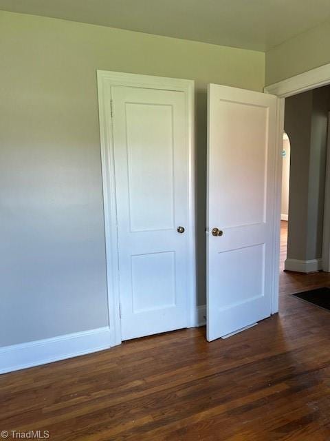 unfurnished bedroom featuring dark wood-type flooring