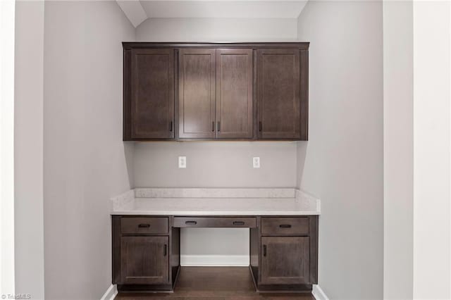 unfurnished office with dark wood-type flooring and built in desk