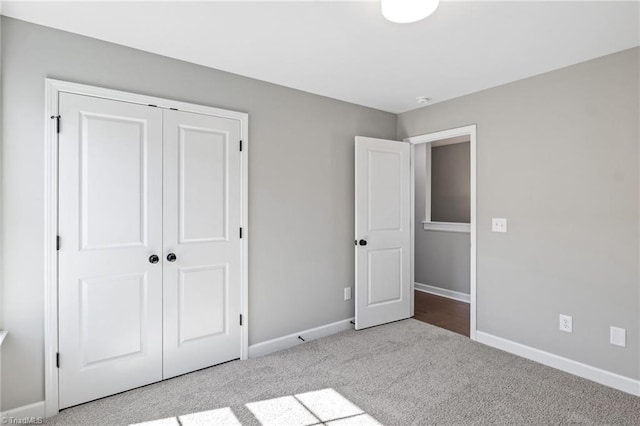 unfurnished bedroom featuring light colored carpet and a closet