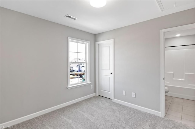 unfurnished bedroom with light carpet and ensuite bath