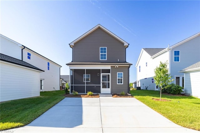 rear view of property with a sunroom, a patio area, and a lawn