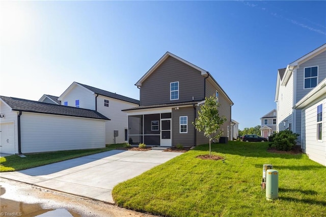 back of property with a yard and a sunroom