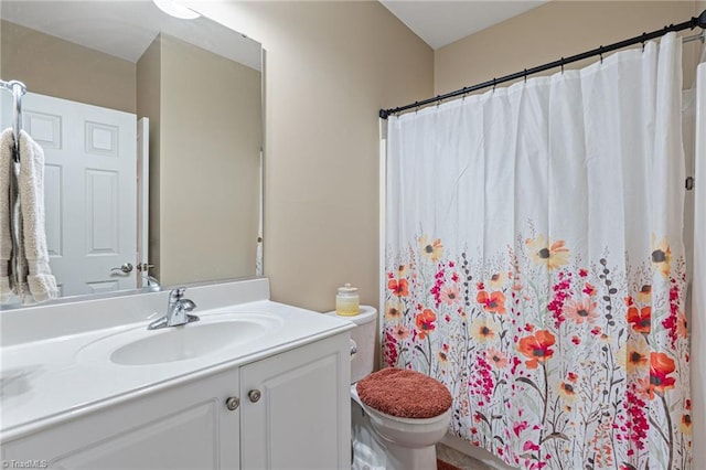 bathroom featuring toilet, vanity, and a shower with curtain