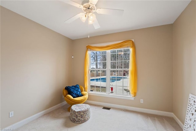 sitting room with visible vents, baseboards, carpet, and a ceiling fan