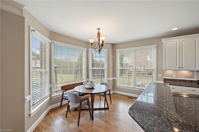 dining space with light wood finished floors, a chandelier, recessed lighting, and baseboards