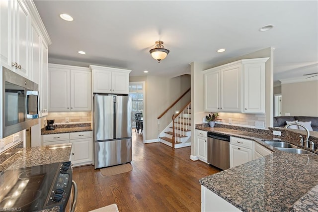 kitchen with a sink, white cabinetry, recessed lighting, appliances with stainless steel finishes, and dark wood-style flooring