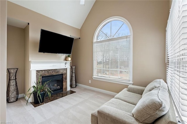 carpeted living room with a wealth of natural light, a fireplace, baseboards, and vaulted ceiling