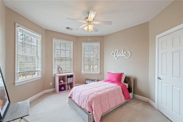 bedroom with light carpet, visible vents, multiple windows, and baseboards