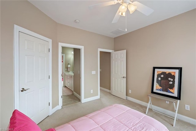 bedroom with ensuite bath, baseboards, and light carpet