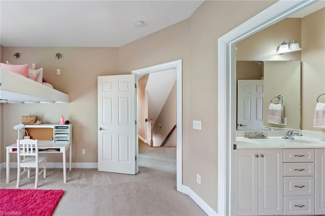 interior space featuring a sink, baseboards, and light carpet