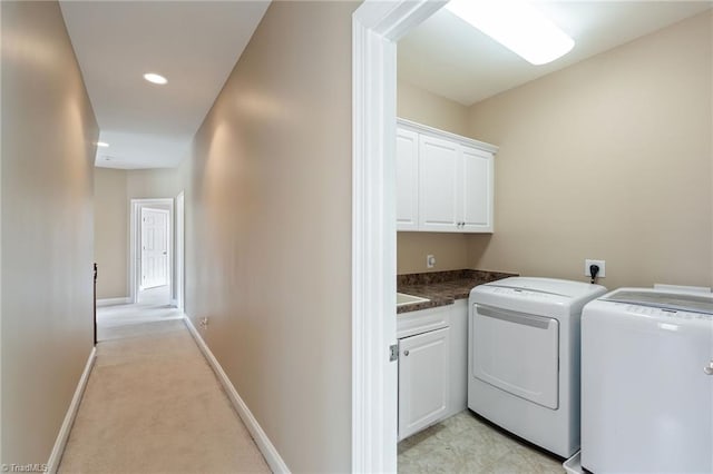 clothes washing area featuring baseboards, washer and clothes dryer, light colored carpet, recessed lighting, and cabinet space