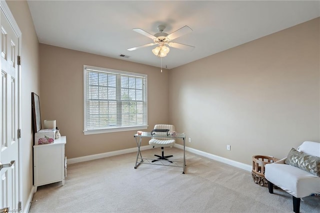 home office featuring visible vents, baseboards, light colored carpet, and a ceiling fan