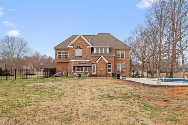 view of front facade with a patio area, a fenced in pool, a front yard, and fence