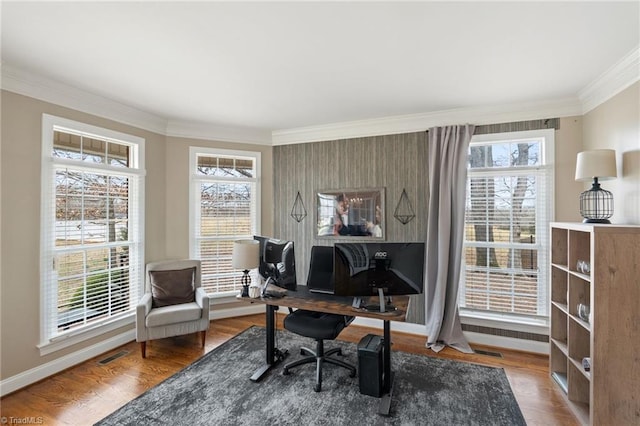 office space with visible vents, crown molding, baseboards, and wood finished floors