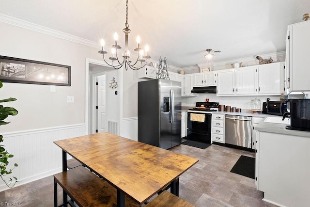 kitchen featuring pendant lighting, white cabinetry, appliances with stainless steel finishes, ornamental molding, and a chandelier