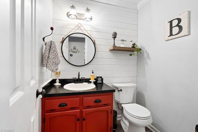 bathroom with toilet, crown molding, and vanity