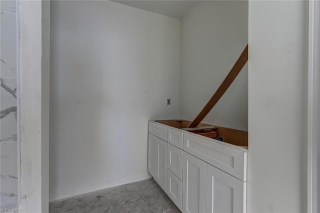 bathroom with unfinished concrete flooring and baseboards