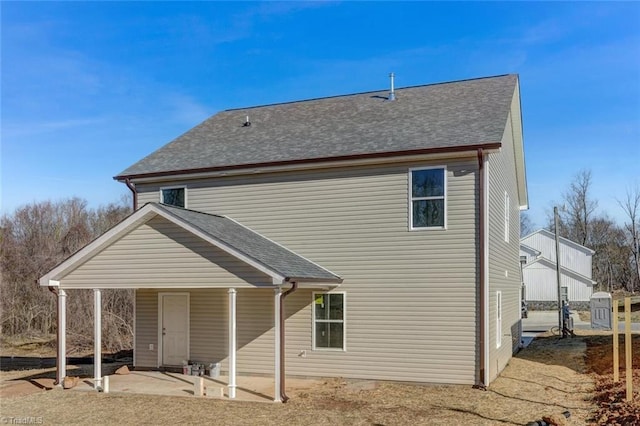 rear view of property with a patio area and a shingled roof