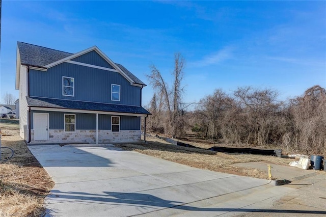 view of front of property featuring stone siding and concrete driveway