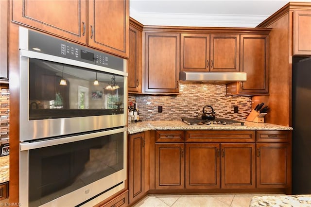 kitchen with crown molding, appliances with stainless steel finishes, tasteful backsplash, brown cabinets, and light stone counters