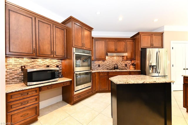 kitchen with decorative backsplash, light tile patterned flooring, built in study area, under cabinet range hood, and appliances with stainless steel finishes