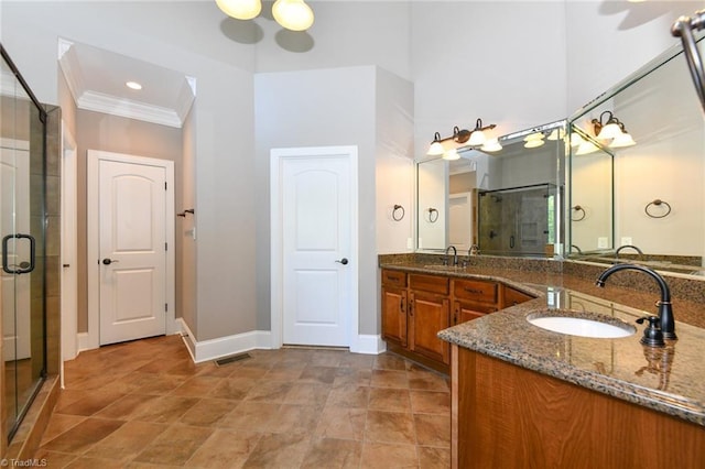 bathroom with crown molding, vanity, stone finish floor, baseboards, and a stall shower