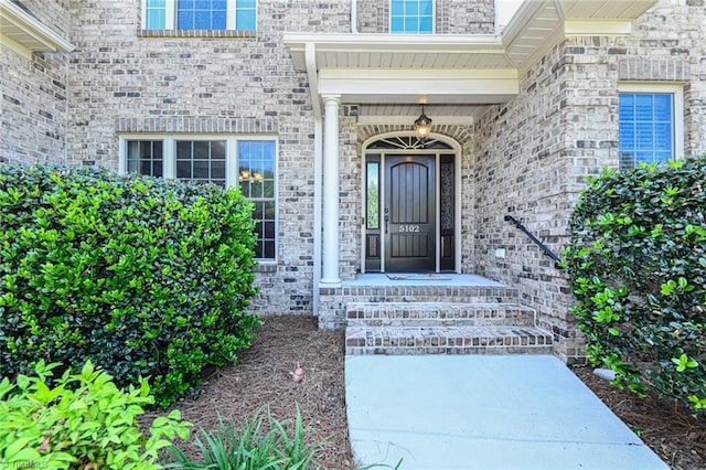 entrance to property featuring brick siding