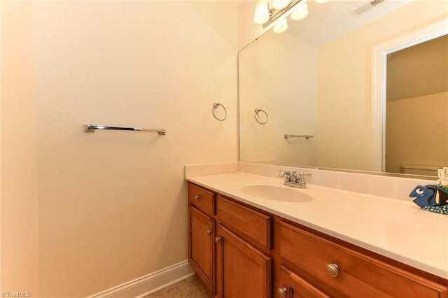 bathroom featuring visible vents, vanity, baseboards, tile patterned floors, and toilet