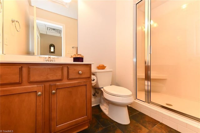 bathroom with vanity, a shower stall, and toilet