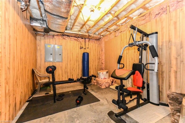 workout room with wood walls and electric panel
