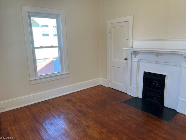 unfurnished living room with a wealth of natural light and dark wood-type flooring