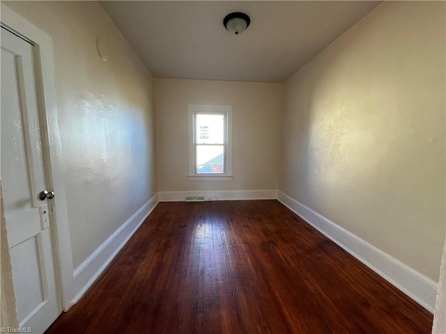 unfurnished room with dark hardwood / wood-style flooring