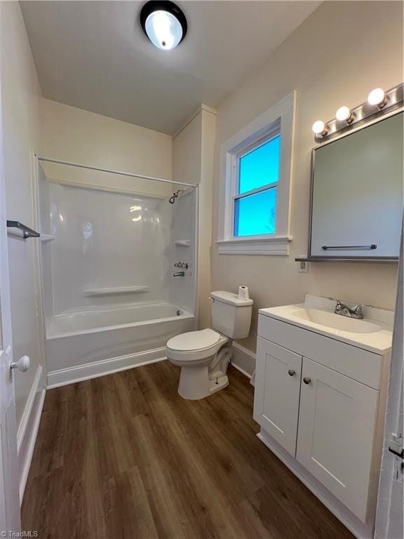 full bathroom with washtub / shower combination, wood-type flooring, vanity, and toilet