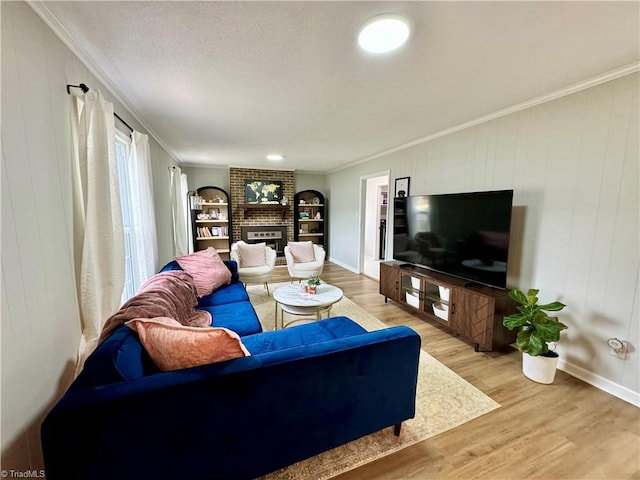 living room with crown molding, a fireplace, wooden walls, and light hardwood / wood-style flooring