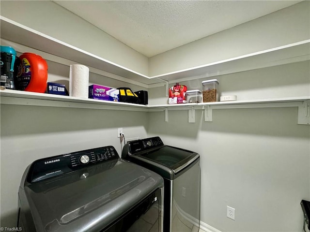 laundry area featuring washer and clothes dryer and a textured ceiling