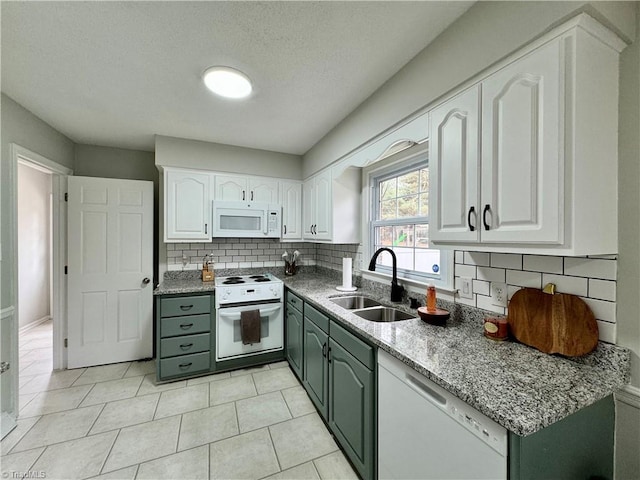 kitchen featuring tasteful backsplash, white cabinetry, sink, and white appliances