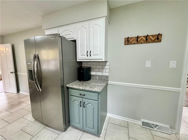 kitchen with white cabinets, decorative backsplash, light tile patterned flooring, and stainless steel fridge with ice dispenser