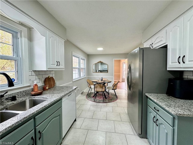 kitchen featuring white cabinets, a wealth of natural light, and dishwasher