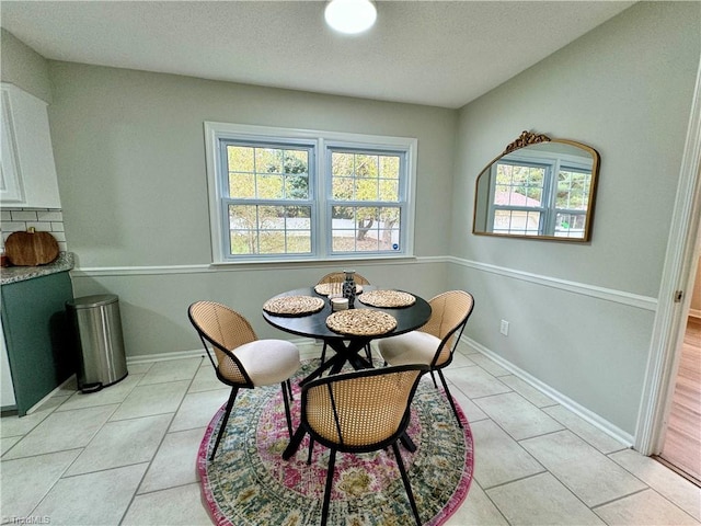 dining room with light tile patterned flooring and a textured ceiling