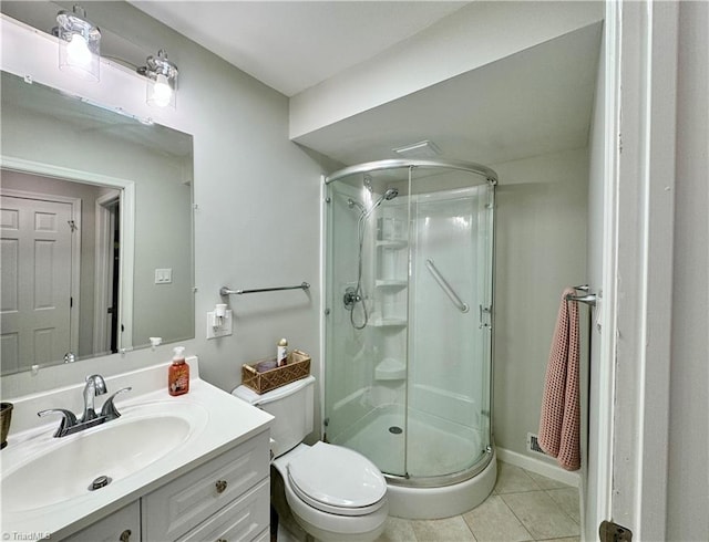 bathroom featuring toilet, vanity, tile patterned floors, and a shower with door