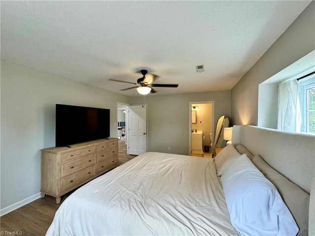 bedroom featuring a textured ceiling, ensuite bathroom, ceiling fan, and dark hardwood / wood-style floors