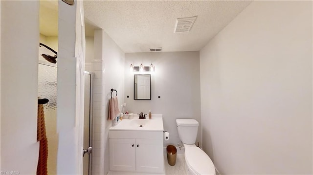 bathroom with toilet, vanity, a textured ceiling, and walk in shower