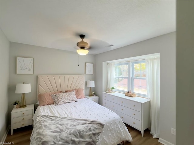 bedroom with dark hardwood / wood-style flooring and ceiling fan